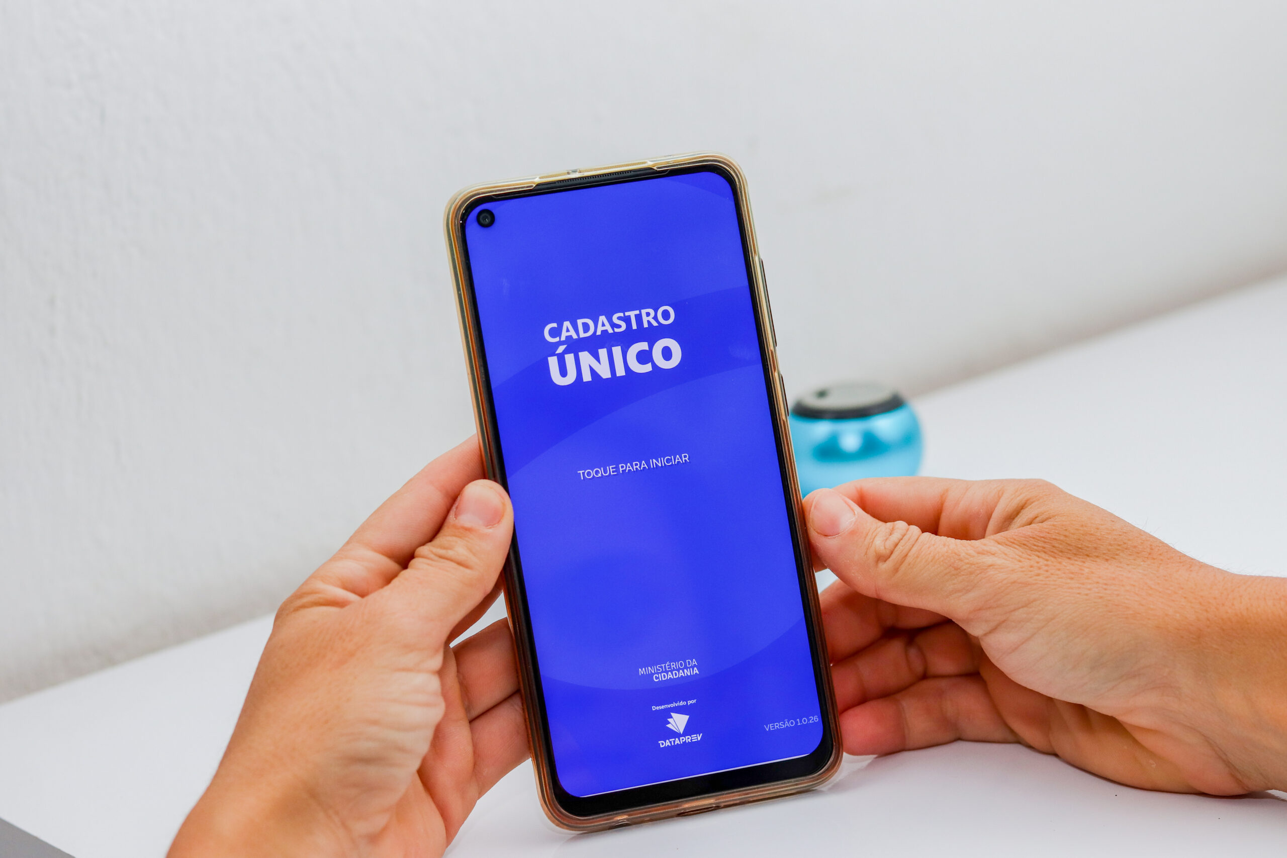 Homem mexendo no app CadÚnico.